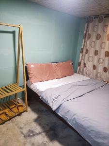 Cama pequeña en habitación con marco de cama en DALAT INN PEACEFUL en Da Lat