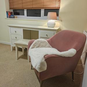 Zimmer mit einem Schreibtisch und einem Stuhl mit einer Decke in der Unterkunft Alexandra Park in Manchester