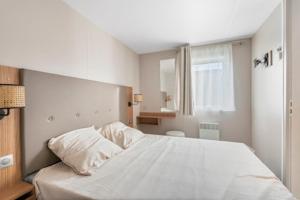 - une chambre avec un lit blanc et une fenêtre dans l'établissement Beachside Vakantiepark, à Blankenberge