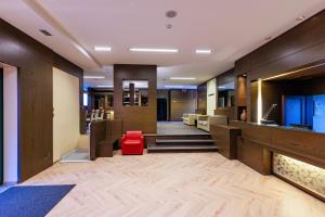 a lobby with a fireplace and a red chair at Hotel Villa Delle Rose - Malpensa in Oleggio