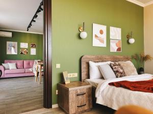 a bedroom with a bed and a pink couch at Sunset Apartment in Batumi