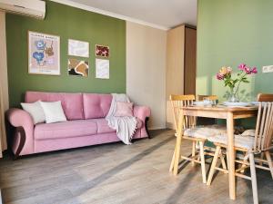 a living room with a pink couch and a table at Sunset Apartment in Batumi