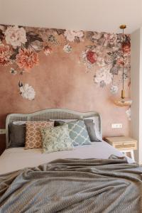 um quarto com uma cama com flores na parede em Patio de Luces em Jumilla