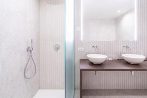 a bathroom with two sinks and a shower at Parkhotel Kortrijk in Kortrijk