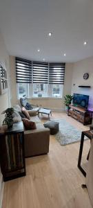 a living room with a couch and a flat screen tv at Paisley Pattern Flat West End UWS UNI GLA Glasgow Airport in Elderslie