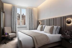 una camera da letto con un grande letto bianco e una finestra di The Pantheon Iconic Rome Hotel, Autograph Collection a Roma