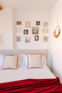 a bedroom with a white bed with a red blanket on it at Patio de Luces in Jumilla
