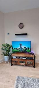 a flat screen tv in a living room at Paisley Pattern Flat West End UWS UNI GLA Glasgow Airport in Elderslie