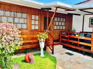 a wooden house with a vase of flowers on the porch at CHALET TARAPOTO in Tarapoto