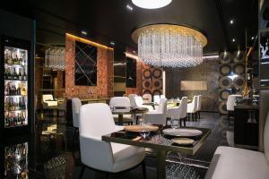 a restaurant with white chairs and a chandelier at The Pantheon Iconic Rome Hotel, Autograph Collection in Rome