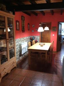 cocina con mesa, sillas y paredes rojas en Casa Lula 1 Pendueles LLanes, en Llanes