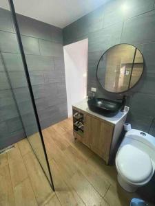 een badkamer met een toilet, een wastafel en een spiegel bij Casa Blanca Cabaña de lujo rodeada de naturaleza in Copacabana