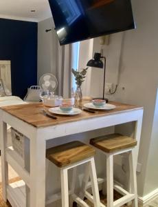 Wyspa kuchenny z dwoma stołkami i stołem w obiekcie Stay on Main - Studio Blue w mieście Paarl