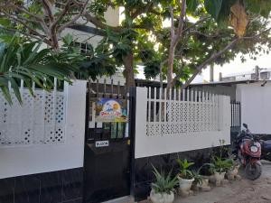 a white fence with a black door and a tree at Brisas del Mar Apto 1A in San Andrés