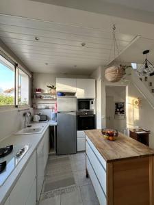 eine Küche mit einem Kühlschrank und einer Arbeitsplatte in der Unterkunft La maison du BONHEUR in Sucy-en-Brie