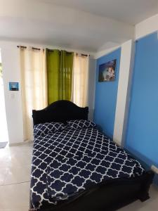 a bedroom with a bed with a blue and white comforter at Brisas del Mar Apto 1A in San Andrés