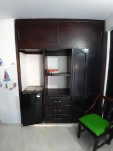 a black cabinet with a green chair in a room at Brisas del Mar Apto 1A in San Andrés