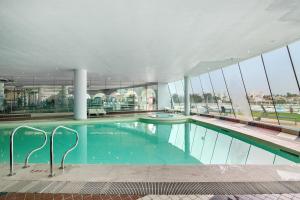 a large swimming pool in a building with windows at Albufeira Haven 103 in Albufeira