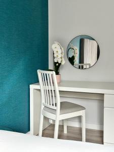 a white chair sitting in front of a desk with a mirror at Sopot Marina Beach Suites in Sopot