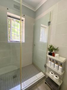 a bathroom with a shower with a glass door at Stay on Main - Studio Blue in Paarl