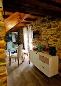 ein Wohnzimmer mit einem Tisch und einer Steinmauer in der Unterkunft PampiHouse in Pampilhosa da Serra