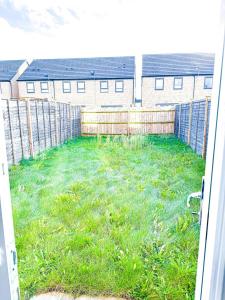 a yard with a fence and green grass at 3Bed House For Contractors Large Group Sleep upto9 in Birmingham