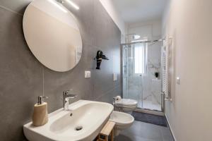 a bathroom with a sink and a toilet and a mirror at Miki's Home in Bari