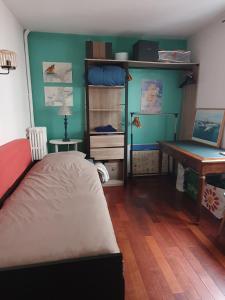 um quarto com uma cama, uma secretária e uma mesa em Chambre privée au calme chez l'habitant em Montrouge
