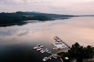 um grupo de barcos ancorados numa doca num lago em Kompleks Tawerna Vito - Apartamenty Vito em Czorsztyn