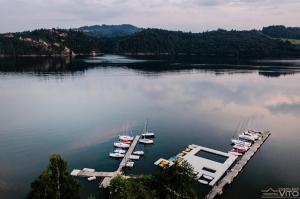 un groupe de bateaux amarrés à un quai sur un lac dans l'établissement Kompleks Tawerna Vito - Apartamenty Vito, à Czorsztyn