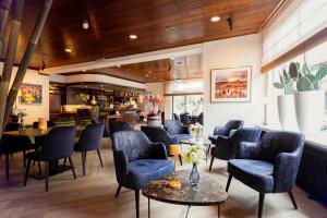 een wachtkamer met blauwe stoelen en tafels bij Hotel Van der Maas in Ootmarsum