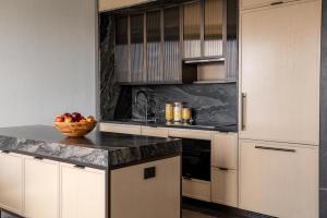 una cocina con armarios blancos y un bol de fruta en una barra en Maison Hudson en Nueva York