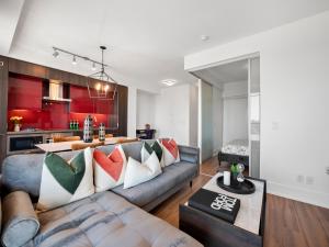 een woonkamer met een bank en een keuken bij Stylish One Bedroom Suite - Entertainment District Toronto in Toronto