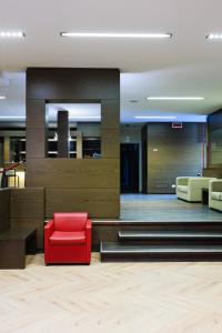 a lobby with a red chair in a room at Hotel Villa Delle Rose - Malpensa in Oleggio