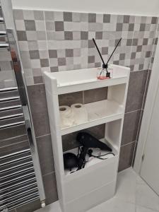 a white shelf in a corner of a bathroom at n&ghomesweethome Monet Elegante appartamento casa vacanze - affari in Milan