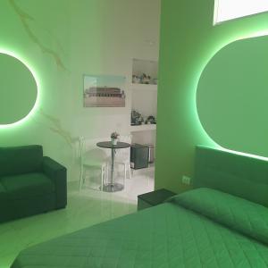 una camera verde con letto e tavolo di Elegance B&B a Napoli