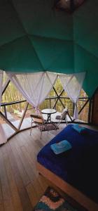 a bedroom with a tent with a bed and a table at Glamping y Cabañas Alpina in Buga