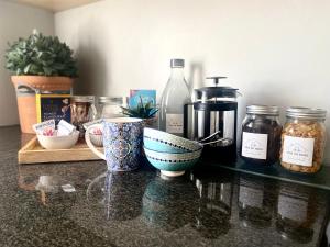 a counter with bowls and jars on a table at Stay on Main - Studio Blue in Paarl +2 photos
