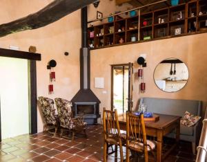 een eetkamer met een tafel en een open haard bij Casa Rural La Cepedana in Cogorderos