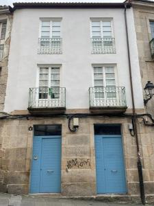 two blue doors on the side of a building at Apartamentos SARABIA DARRIBA in Ourense