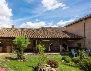 ein Haus mit einem gefliesten Dach und einem Hof in der Unterkunft Casa Rural La Cepedana in Cogorderos