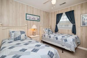 sypialnia z dwoma łóżkami i oknem w obiekcie Dip Inn by Oak Island Accommodations w mieście Oak Island
