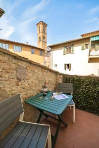 a table and chairs on a patio with a clock tower at San Niccolò Luxury Apartment in Florence
