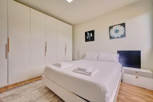 a white bedroom with a large bed and white cabinets at Casa Viana by Clabao in Viana