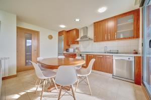 a kitchen with a wooden table and white chairs at Casa Viana by Clabao in Viana