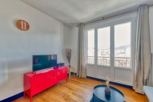 a living room with a tv and a red dresser at La Dolce Vita¶ Belle vue ¶ Confort ¶Proche TRAM in Grenoble