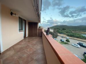 - un balcon avec vue sur le parking dans l'établissement Attico con vista mozzafiato ! Golfo di Marinella, à Golfo Aranci