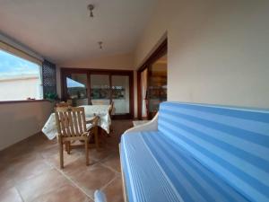 - une chambre avec un lit, une chaise et une table dans l'établissement Attico con vista mozzafiato ! Golfo di Marinella, à Golfo Aranci