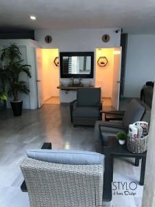 - un salon avec un canapé, des chaises et une télévision dans l'établissement Hotel Monumental, à Aguascalientes