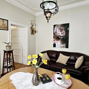 een woonkamer met een leren bank en een tafel bij Apartman Didi in Belgrado